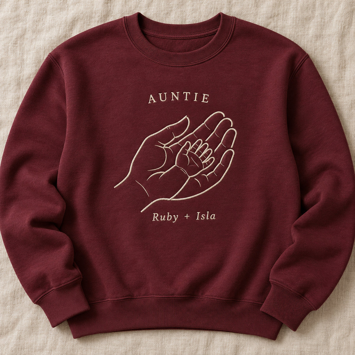 Handful of Love personalized Auntie hands design; Maroon sweatshirt mockup, hero; sample text AUNTIE / Ruby + Isla