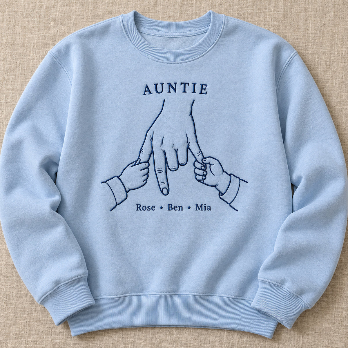 Double Little Hold personalized Auntie hands design; Light Blue sweatshirt mockup, hero; sample text AUNTIE / Rose • Ben • Mia