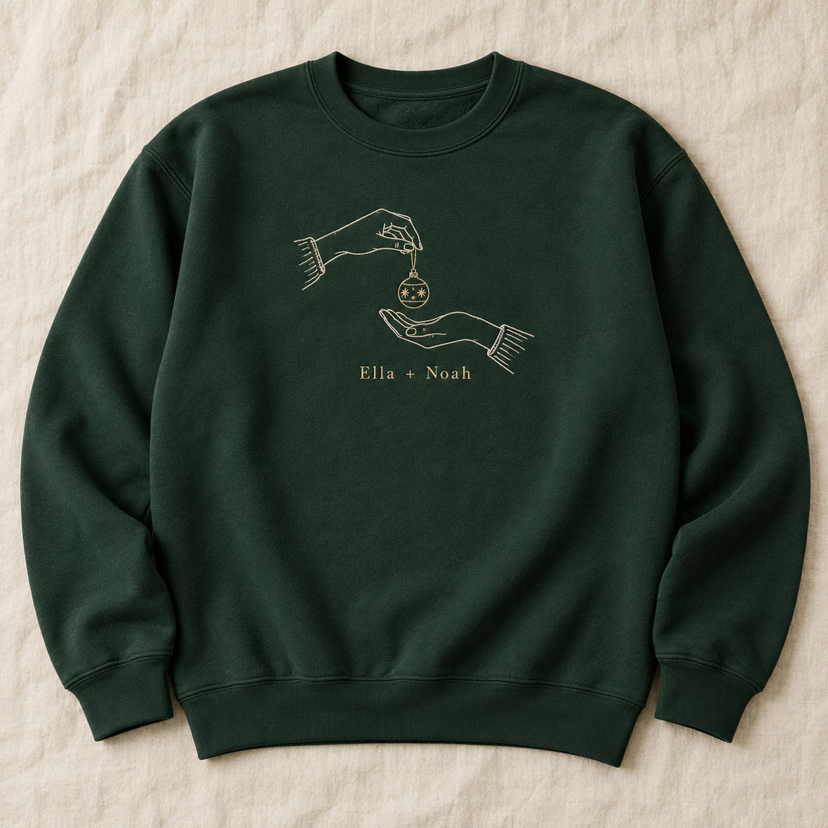 Ornament Exchange personalized Christmas hands design; Forest Green sweatshirt mockup, hero; sample text Ella + Noah