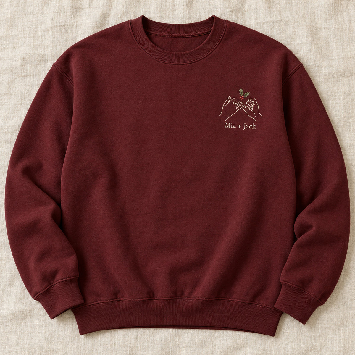 Holiday Pinky Promise personalized Christmas hands design; Maroon sweatshirt mockup, hero; sample text Mia + Jack
