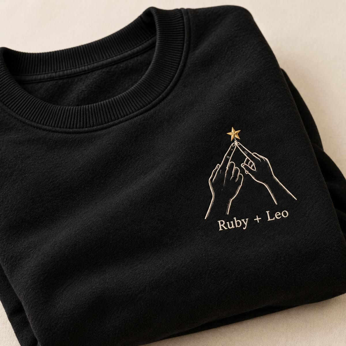 Hanging Our Star personalized Christmas hands design; Black sweatshirt mockup, personalization detail; sample text Ruby + Leo