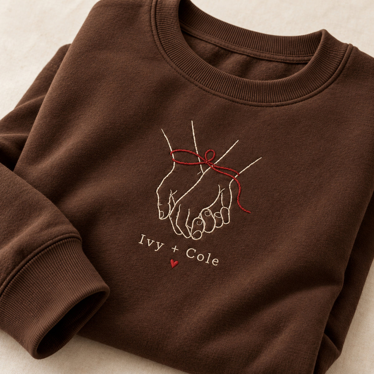 Ribbon Around Us personalized Christmas hands design; Chocolate sweatshirt mockup, personalization detail; sample text Ivy + Cole