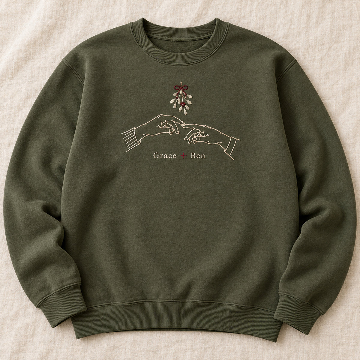 Hands Under Mistletoe personalized Christmas hands design; Military Green sweatshirt mockup, hero; sample text Grace + Ben