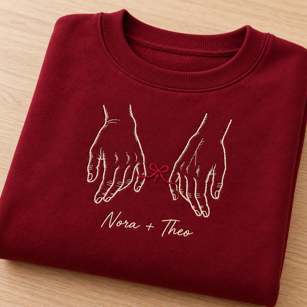 Tied to You personalized Couples hands design; Maroon sweatshirt mockup, personalization detail; sample text Nora + Theo