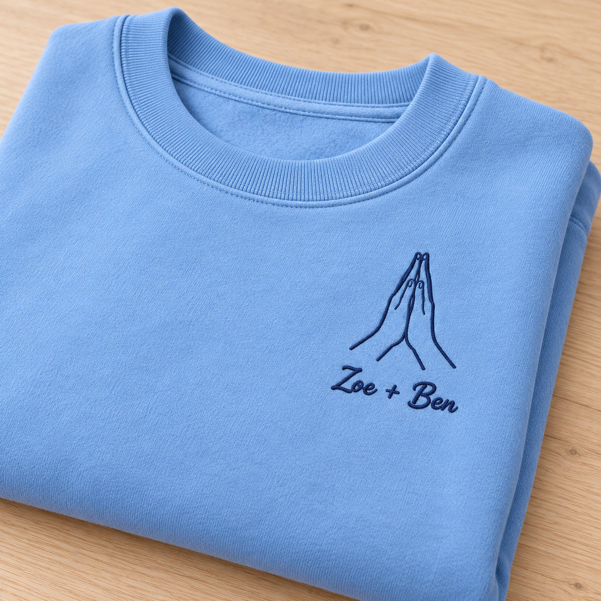 Your Warmth personalized Couples hands design; Carolina Blue sweatshirt mockup, personalization detail; sample text Zoe + Ben