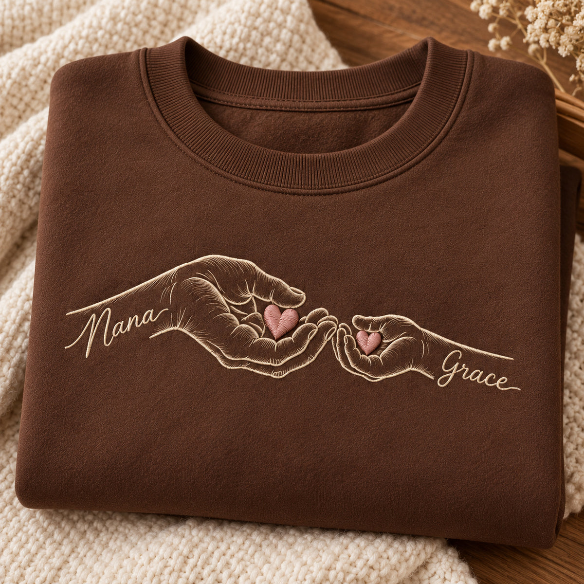 Shared Wishes personalized Grandma hands design; Brown sweatshirt mockup, personalization detail; sample text Nana / Grace
