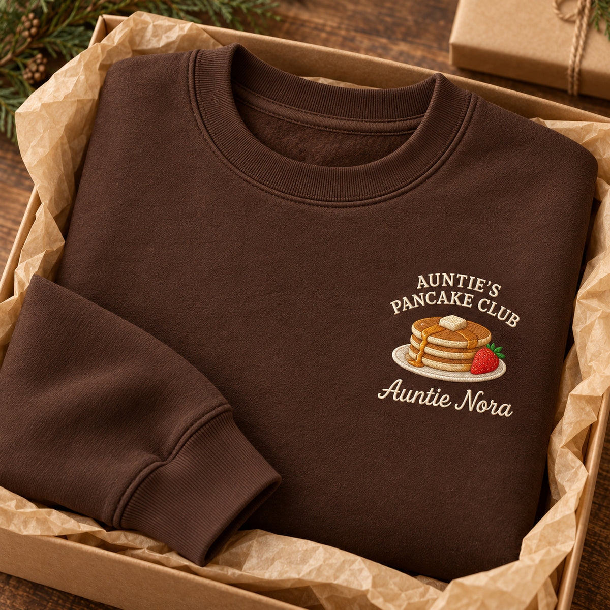 Auntie's Pancake Club sweatshirt concept mockup featuring a stack of pancakes with butter and a strawberry, sample personalization Auntie Nora, personalization view