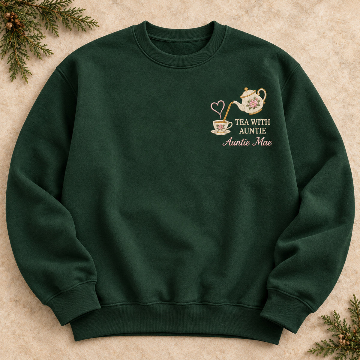 Tea with Auntie sweatshirt concept mockup featuring a floral teapot pouring into a teacup with a heart accent, sample personalization Auntie Mae, hero view