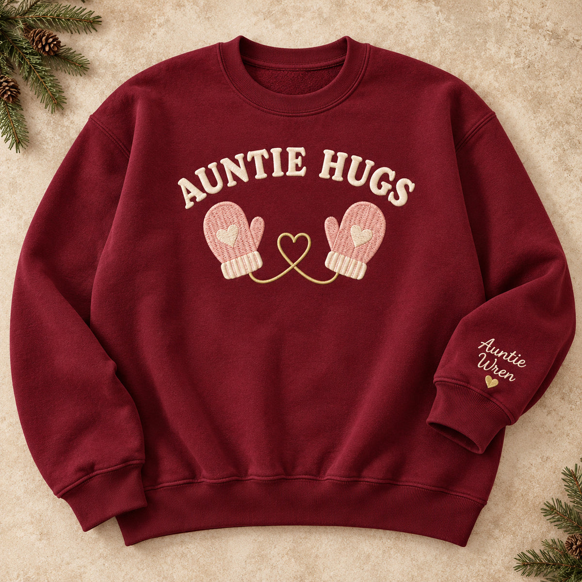 Auntie Hugs sweatshirt concept mockup featuring two mittens linked by a heart-shaped cord, sample personalization Auntie Wren, hero view