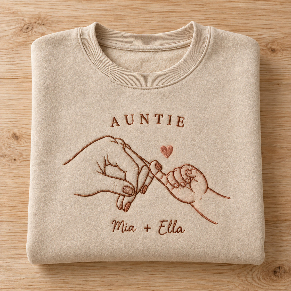 Pinky Adventure personalized Auntie hands design; Sand sweatshirt mockup, personalization detail; sample text AUNTIE / Mia + Ella