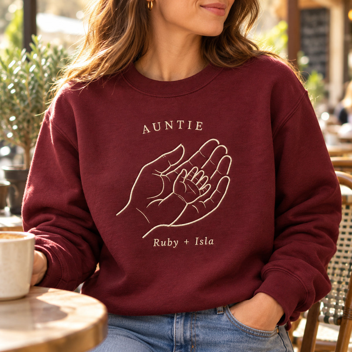Handful of Love personalized Auntie hands design; Maroon sweatshirt mockup, lifestyle; sample text AUNTIE / Ruby + Isla