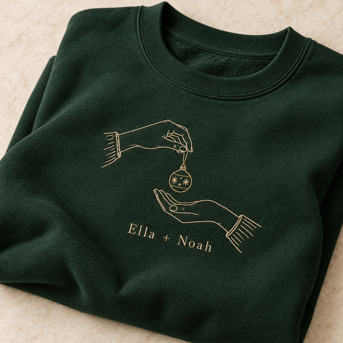 Ornament Exchange personalized Christmas hands design; Forest Green sweatshirt mockup, personalization detail; sample text Ella + Noah