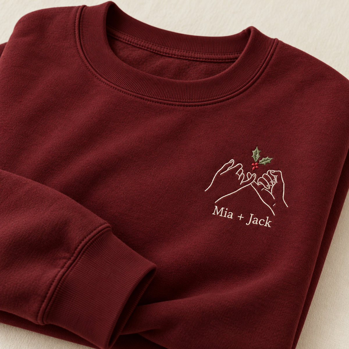 Holiday Pinky Promise personalized Christmas hands design; Maroon sweatshirt mockup, personalization detail; sample text Mia + Jack