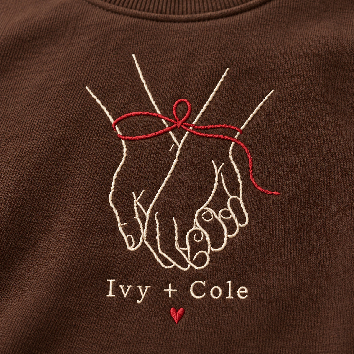 Ribbon Around Us personalized Christmas hands design; Chocolate sweatshirt mockup, embroidery detail; sample text Ivy + Cole
