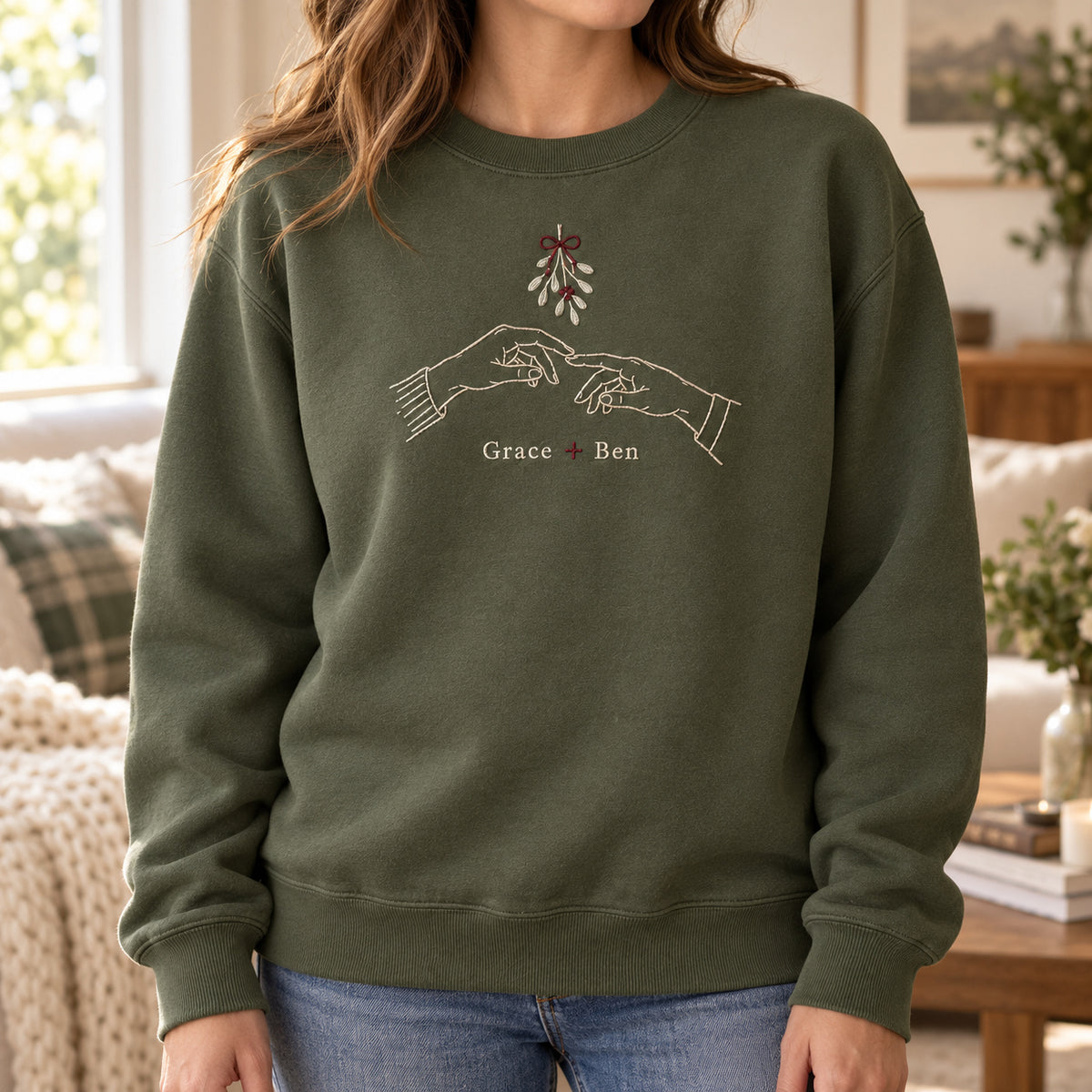 Hands Under Mistletoe personalized Christmas hands design; Military Green sweatshirt mockup, lifestyle; sample text Grace + Ben