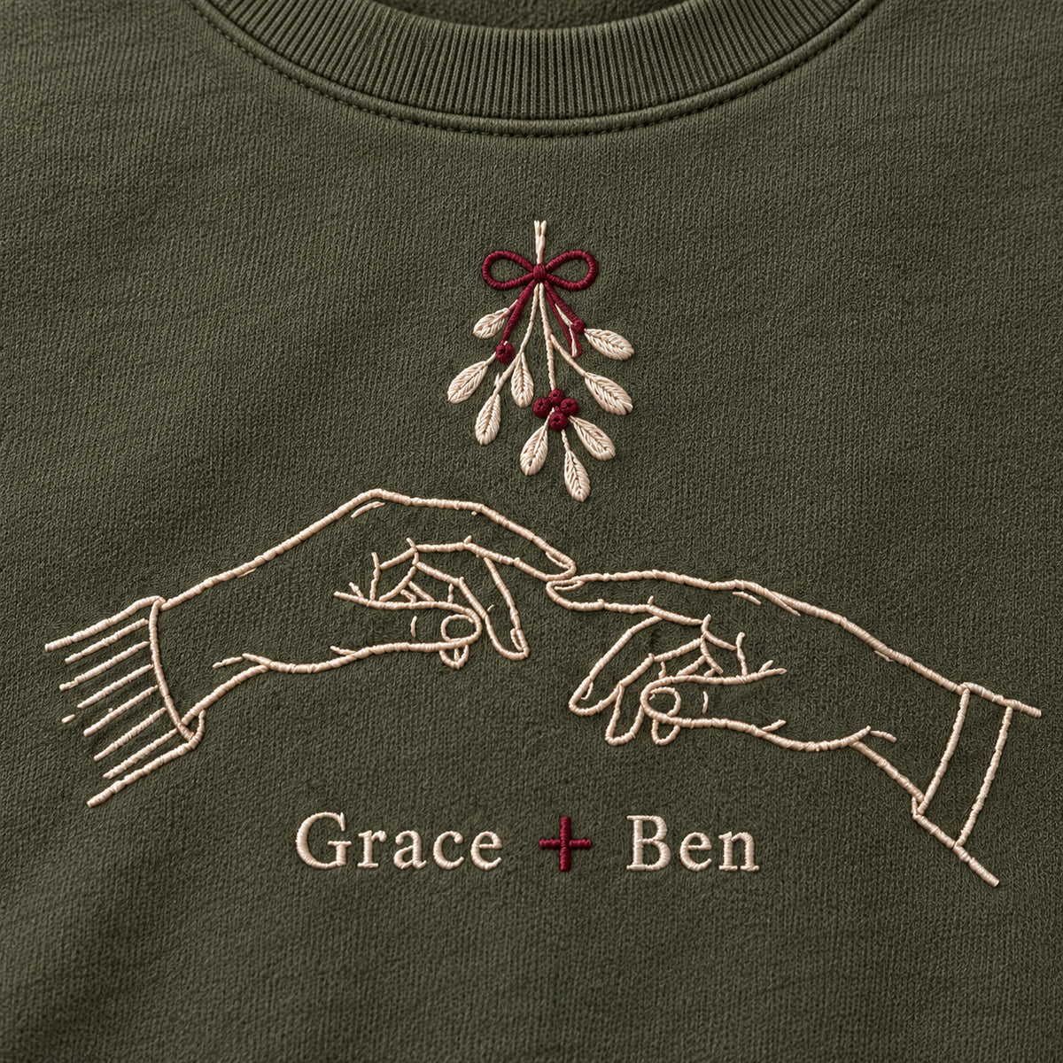 Hands Under Mistletoe personalized Christmas hands design; Military Green sweatshirt mockup, embroidery detail; sample text Grace + Ben