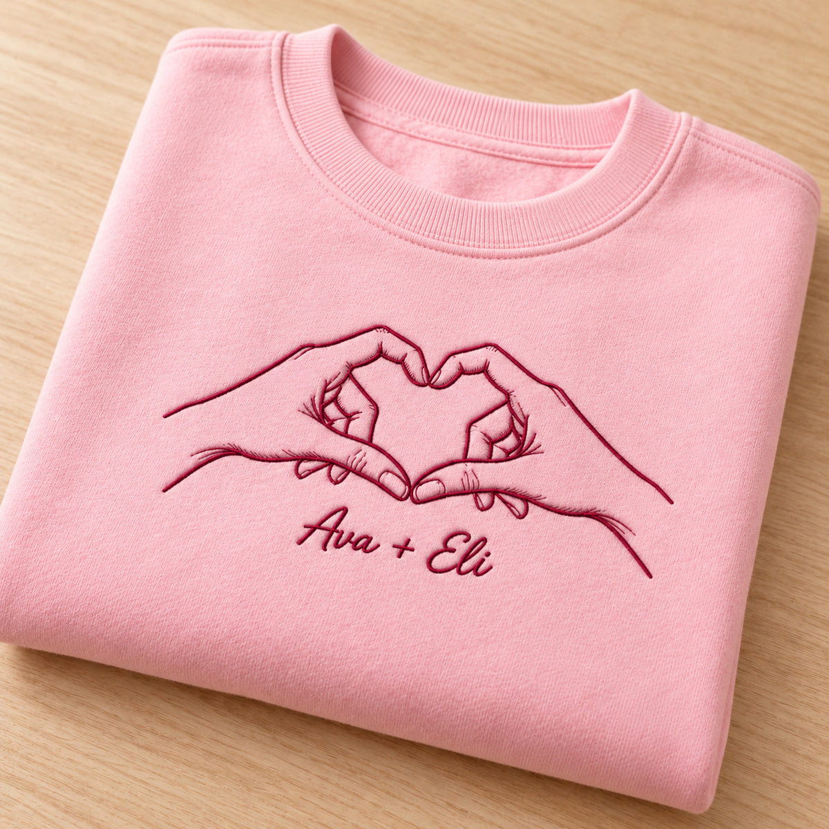 Heart Together personalized Couples hands design; Light Pink sweatshirt mockup, personalization detail; sample text Ava + Eli