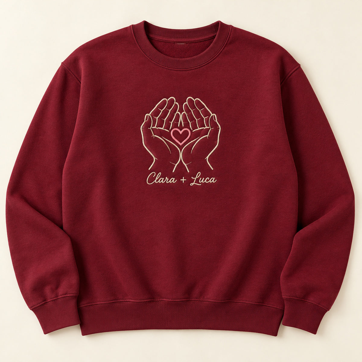 Holding Us personalized Couples hands design; Maroon sweatshirt mockup, hero; sample text Clara + Luca