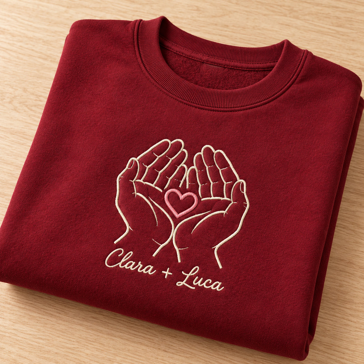Holding Us personalized Couples hands design; Maroon sweatshirt mockup, personalization detail; sample text Clara + Luca