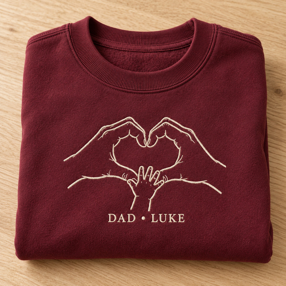 Heart In Our Hands personalized Dad hands design; Maroon sweatshirt mockup, personalization detail; sample text DAD • LUKE