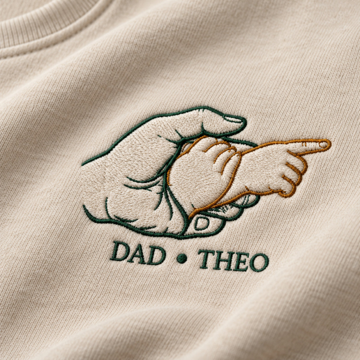Guiding The Way personalized Dad hands design; Beige sweatshirt mockup, embroidery detail; sample text DAD • THEO