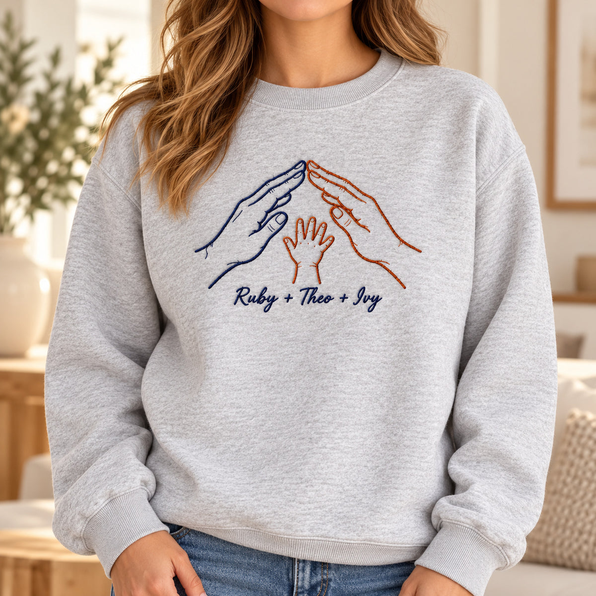 Home in Our Hands personalized Family hands design; Ash sweatshirt mockup, lifestyle; sample text Ruby + Theo + Ivy