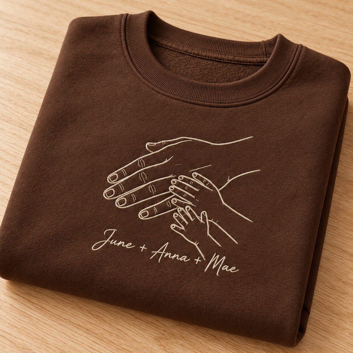 Love Across Generations personalized Family hands design; Chocolate sweatshirt mockup, personalization detail; sample text June + Anna + Mae