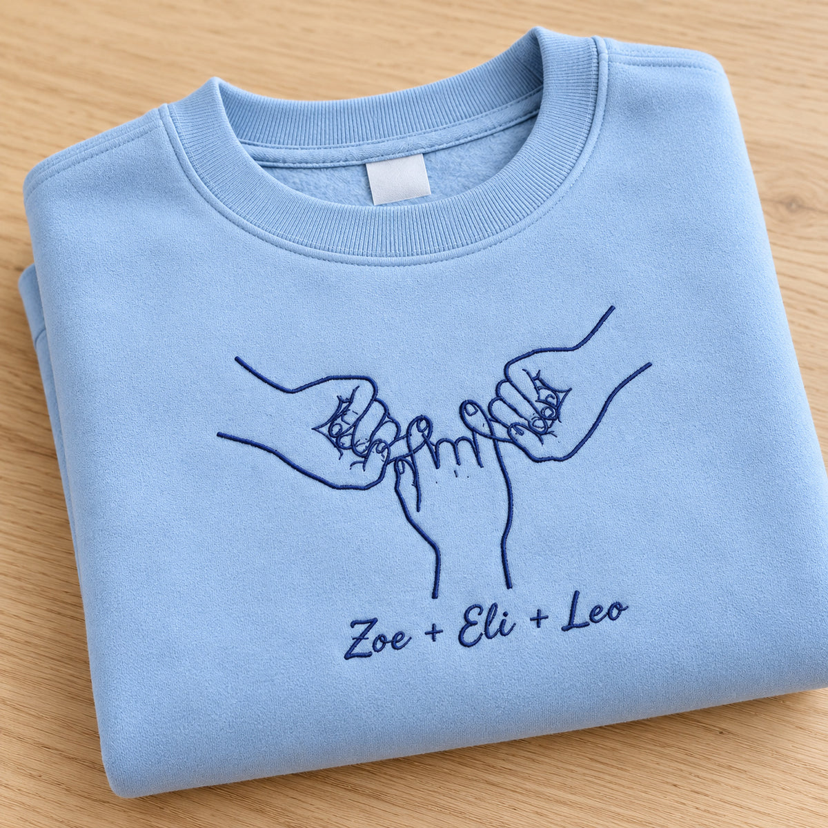 Our Promise personalized Family hands design; Light Blue sweatshirt mockup, personalization detail; sample text Zoe + Eli + Leo