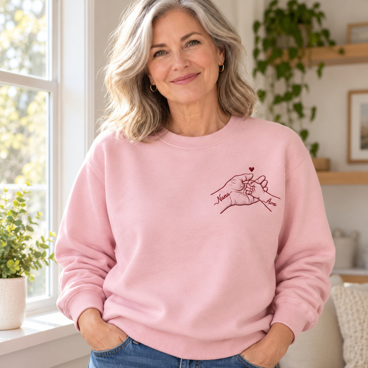 Held Through Life personalized Grandma hands design; Light Pink sweatshirt mockup, lifestyle; sample text Nana / Ava