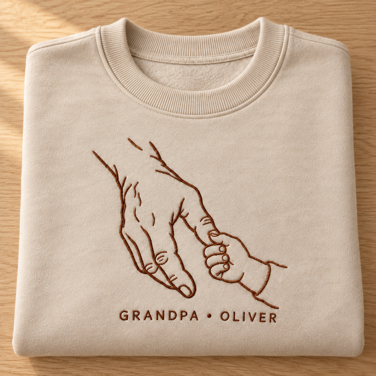 Generations Grip personalized Grandpa hands design; Sand sweatshirt mockup, personalization detail; sample text GRANDPA • OLIVER