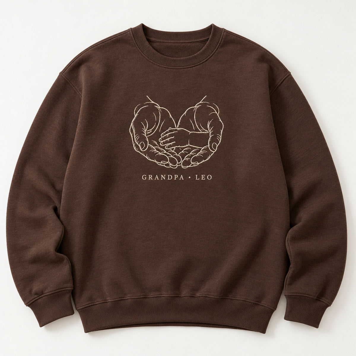 A Gentle Shelter personalized Grandpa hands design; Chocolate sweatshirt mockup, hero; sample text GRANDPA • LEO