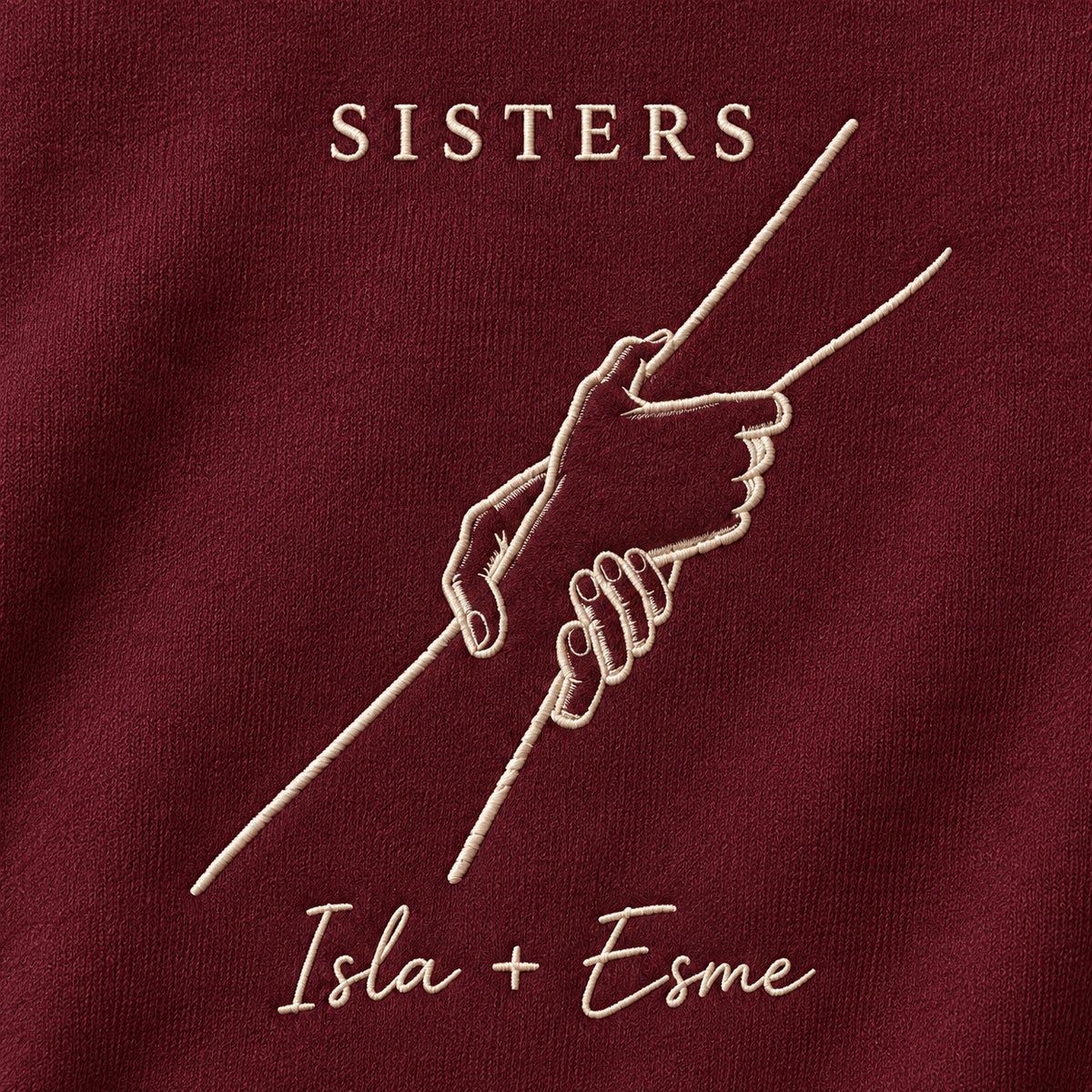 Helping Hand personalized Sister hands design; Maroon sweatshirt mockup, embroidery detail; sample text SISTERS / Isla + Esme
