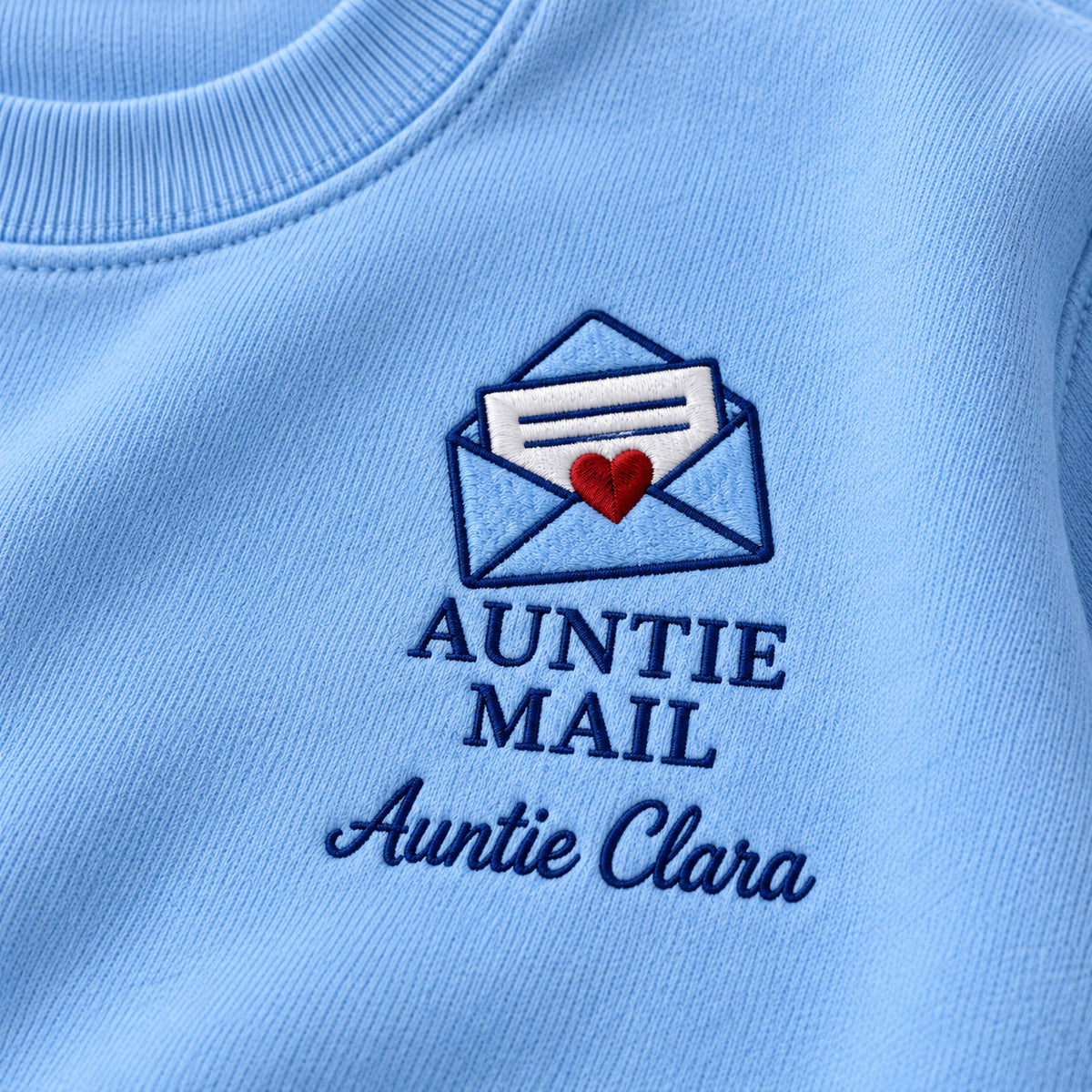 Auntie Mail sweatshirt concept mockup featuring a heart-sealed envelope with a letter, sample personalization Auntie Clara, embroidery view