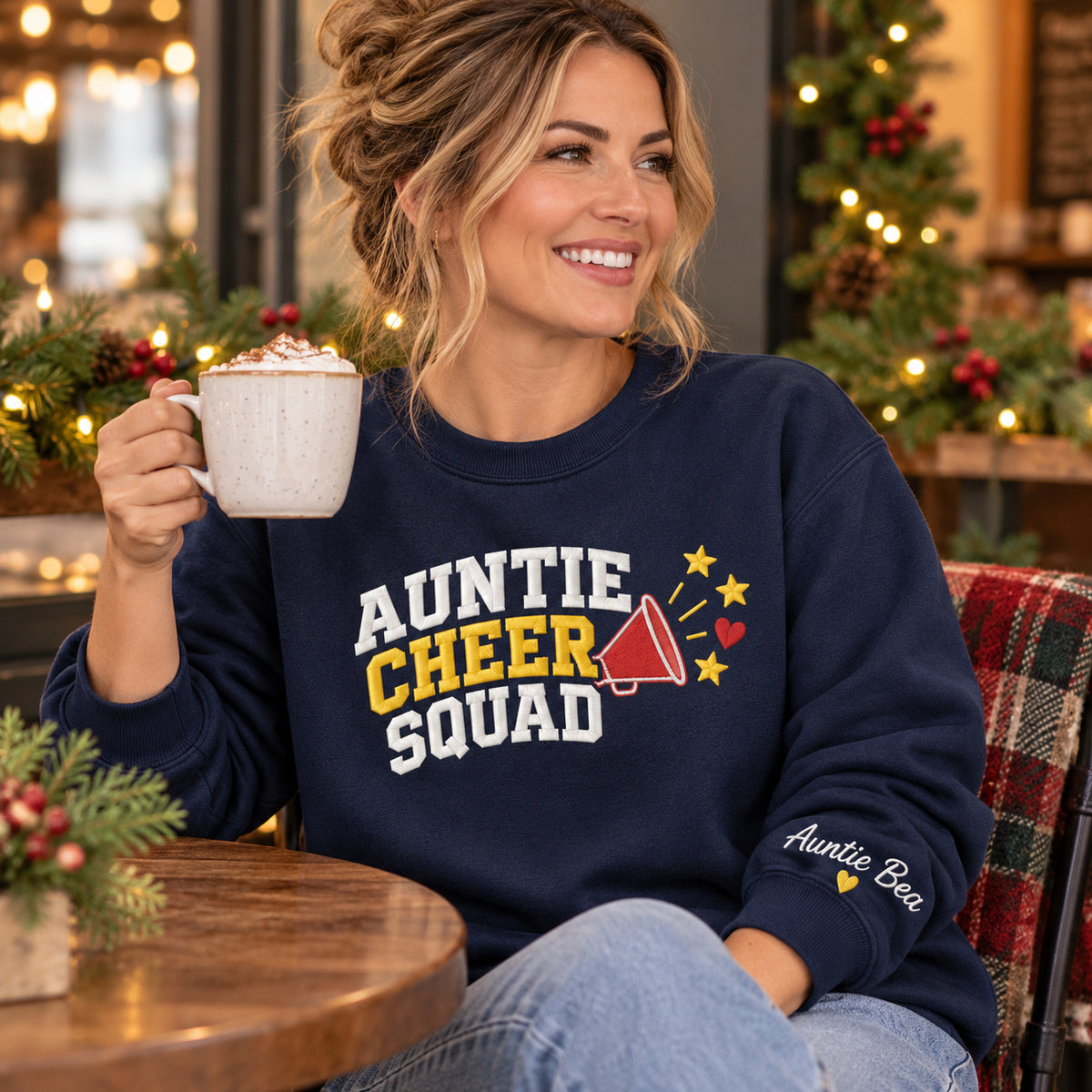 Auntie Cheer Squad sweatshirt concept mockup featuring a megaphone, stars and a small heart beside cheer lettering, sample personalization Auntie Bea, lifestyle view