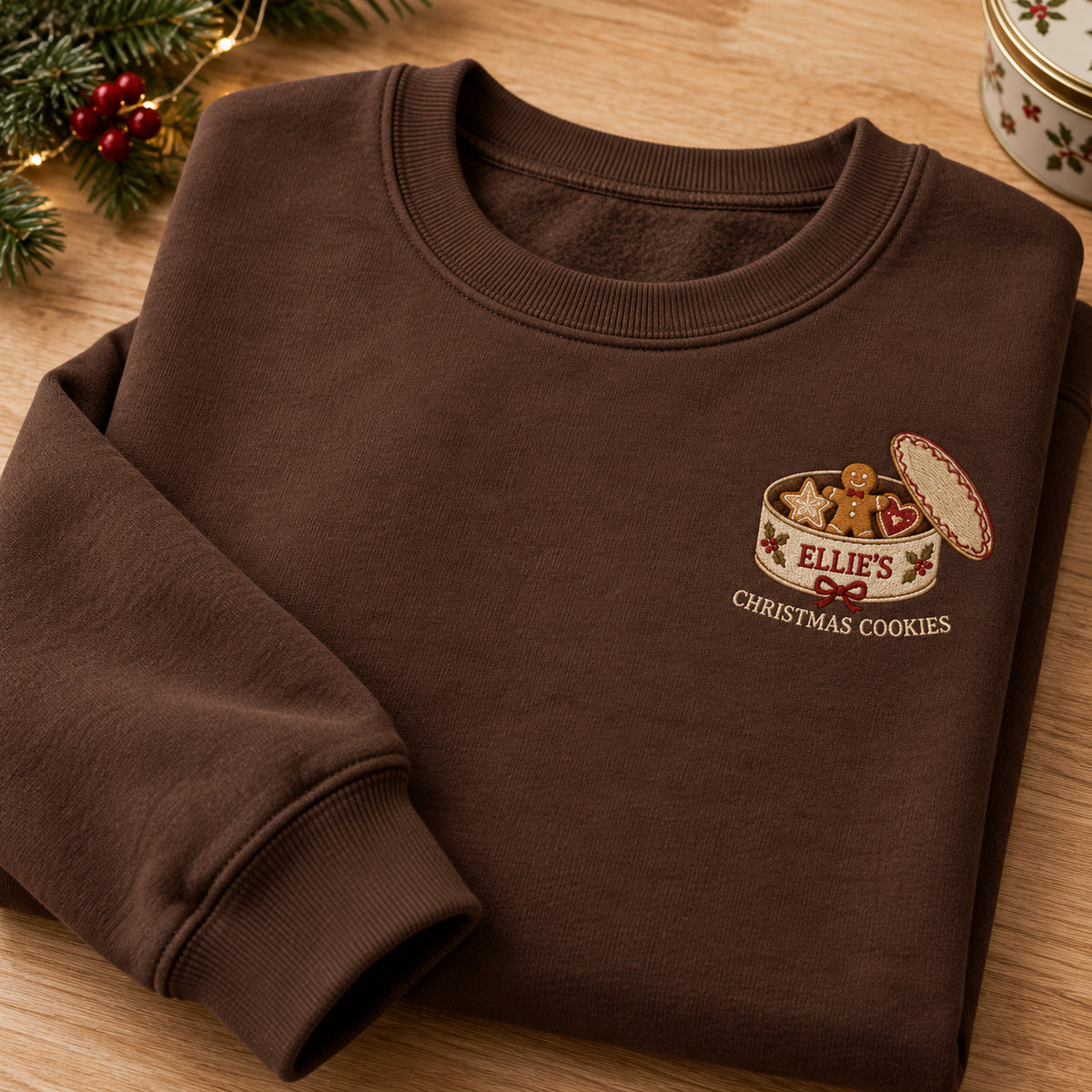 Christmas Cookie Box sweatshirt concept mockup featuring an open Christmas cookie tin with gingerbread, heart and star cookies, sample personalization ELLIE, hero view