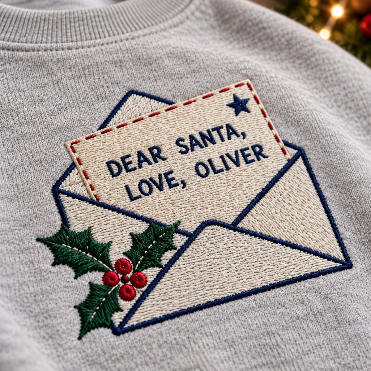 Dear Santa Letter sweatshirt concept mockup featuring a letter to Santa in an envelope with holly, sample personalization OLIVER, embroidery view