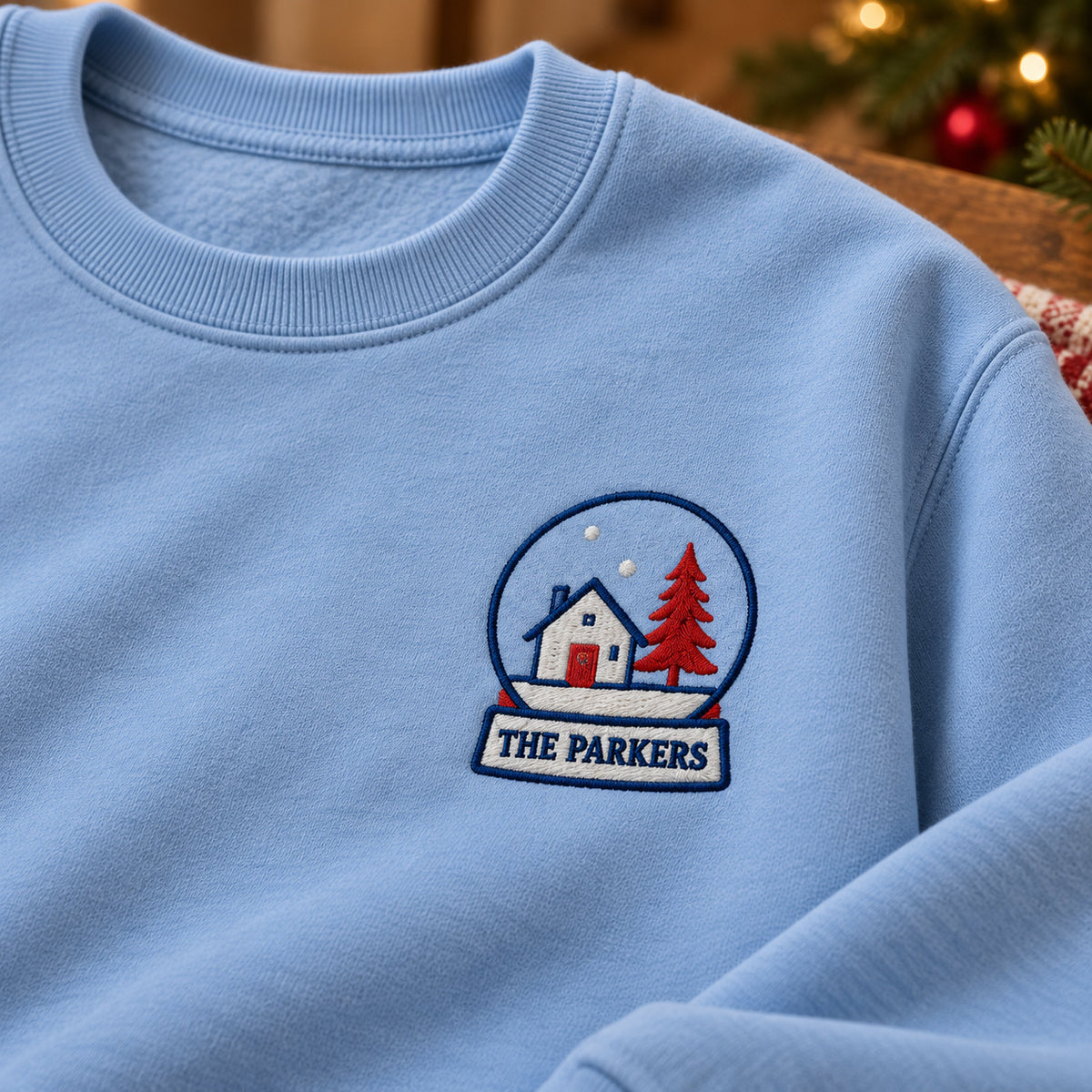 Home Snow Globe sweatshirt concept mockup featuring a house and tree inside a personalized snow globe, sample personalization PARKERS, personalization view
