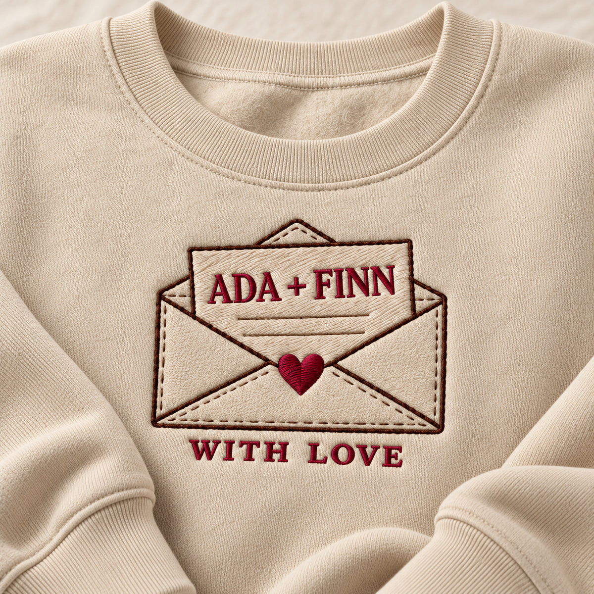 With Love Letter sweatshirt concept mockup featuring a personalized love letter in a heart-sealed envelope, sample personalization ADA + FINN, embroidery view