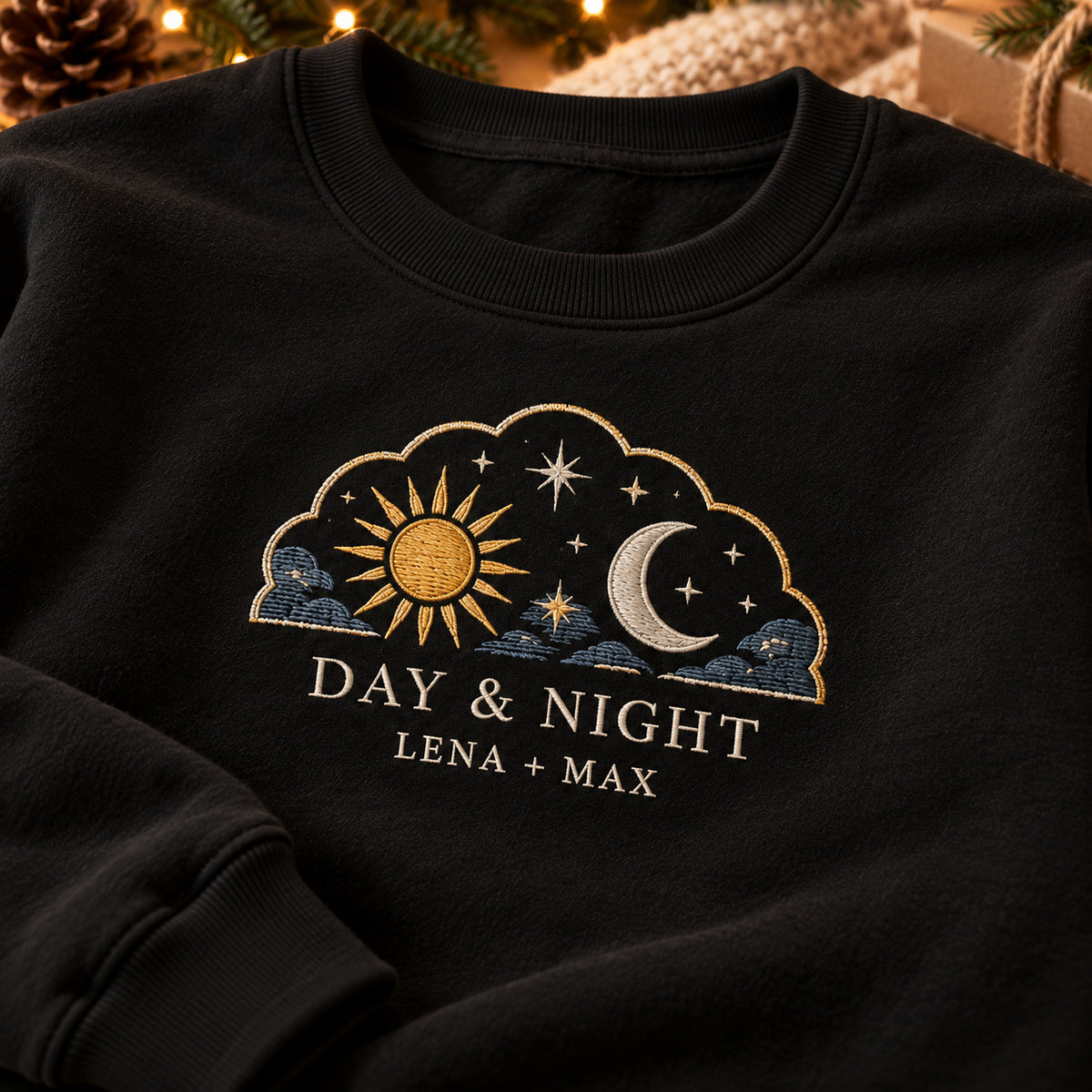 Day and Night sweatshirt concept mockup featuring a sun and crescent moon with stars in a cloud-shaped frame, sample personalization LENA + MAX, embroidery view
