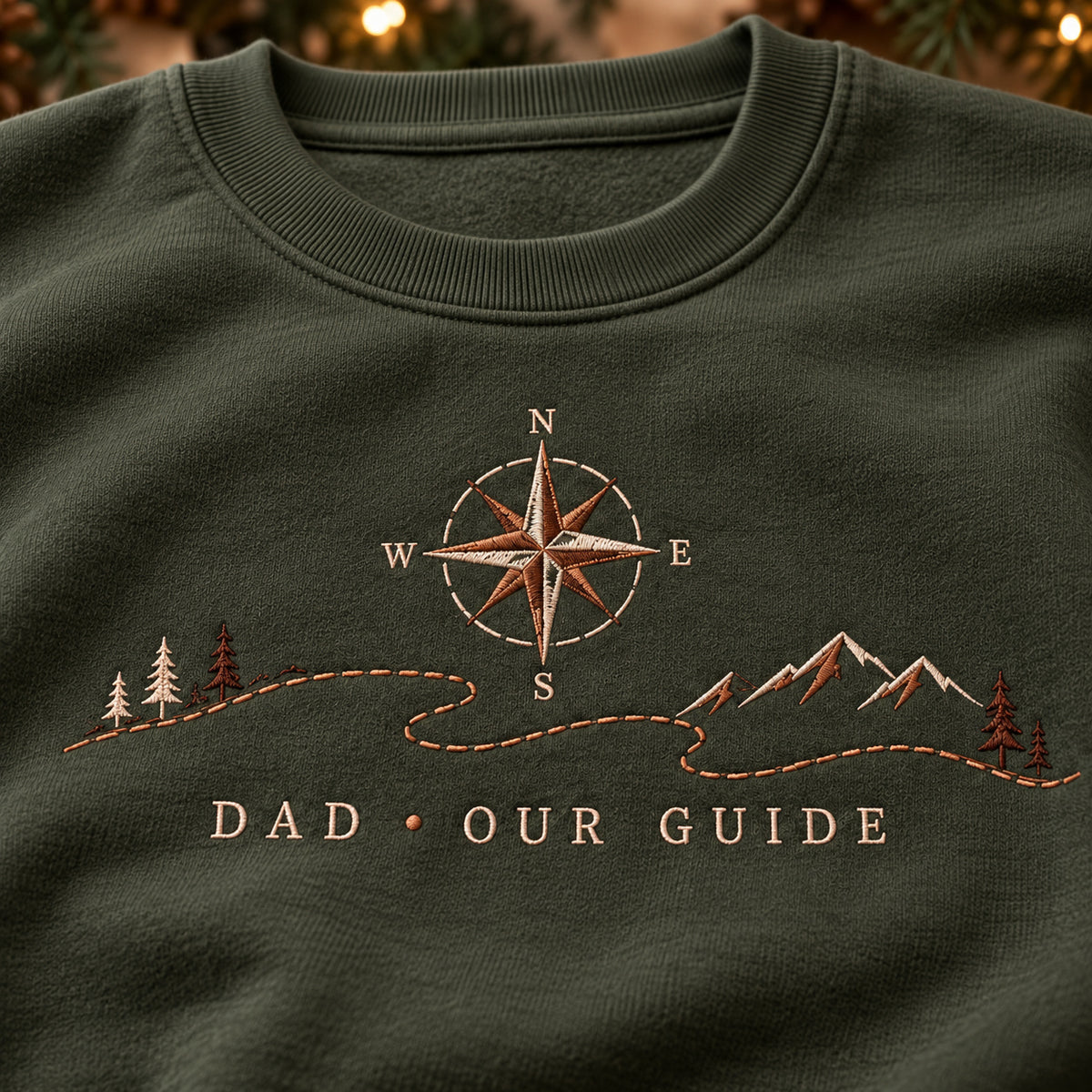 Dad's Compass sweatshirt concept mockup featuring a compass above a mountain landscape and winding path, sample personalization OLIVER + JACK, embroidery view