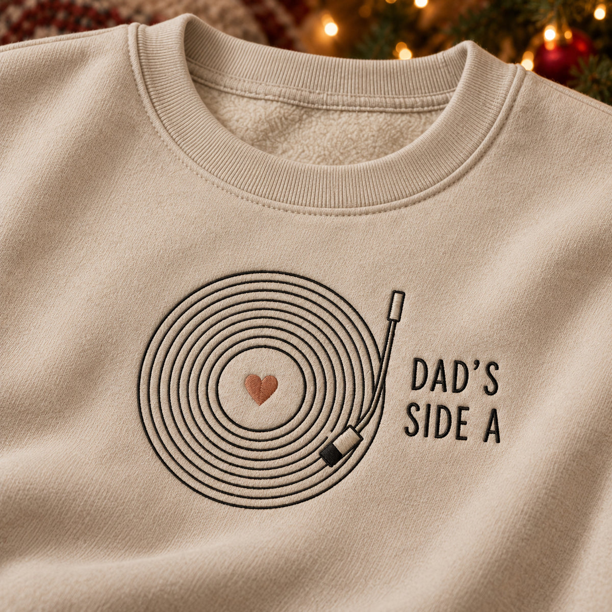 Dad's Vinyl Record sweatshirt concept mockup featuring a vinyl record with a heart center and turntable arm, sample personalization SOPHIE + MAX, embroidery view