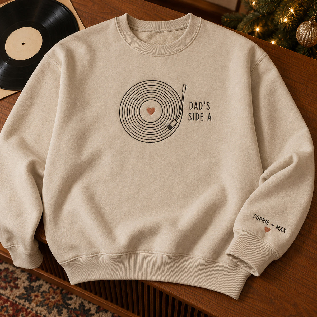 Dad's Vinyl Record sweatshirt concept mockup featuring a vinyl record with a heart center and turntable arm, sample personalization SOPHIE + MAX, hero view