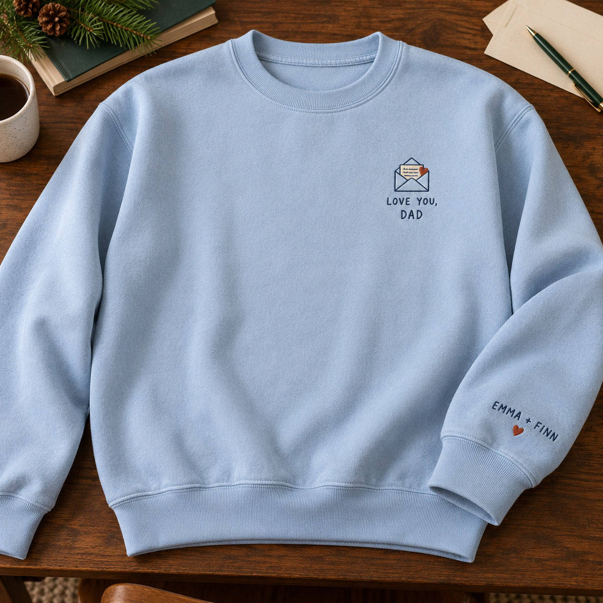 Love You Dad Letter sweatshirt concept mockup featuring a love letter in an envelope with a red heart, sample personalization EMMA + FINN, hero view