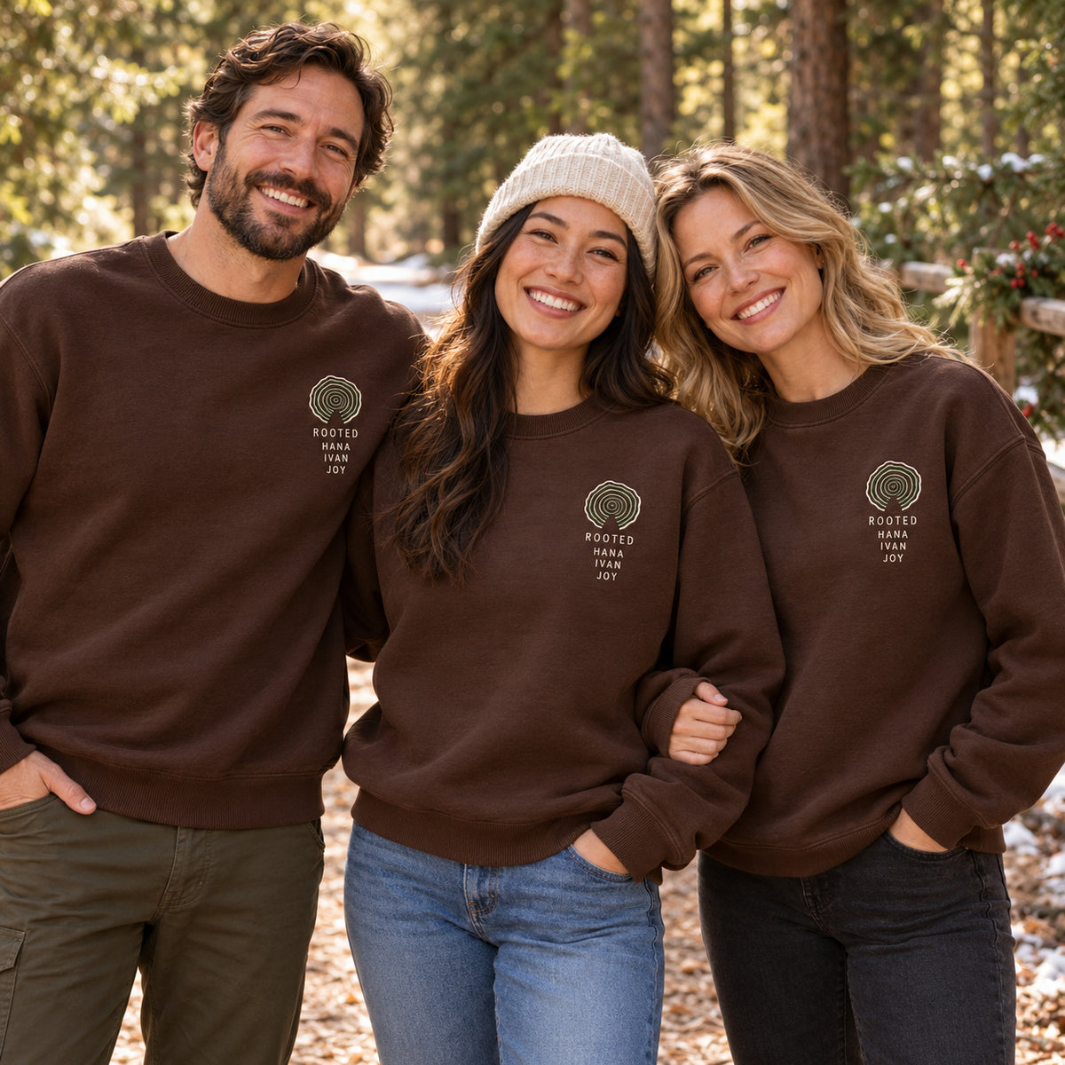 Rooted Family Tree Rings sweatshirt concept mockup featuring concentric tree rings above ROOTED lettering, sample personalization HANA / IVAN / JOY, lifestyle view