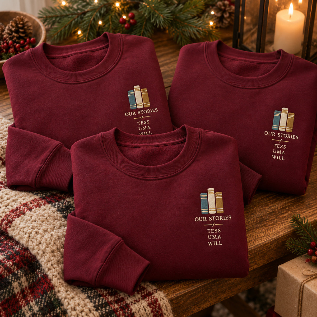 Our Stories Bookshelf sweatshirt concept mockup featuring three upright books above OUR STORIES lettering, sample personalization TESS / UMA / WILL, personalization view