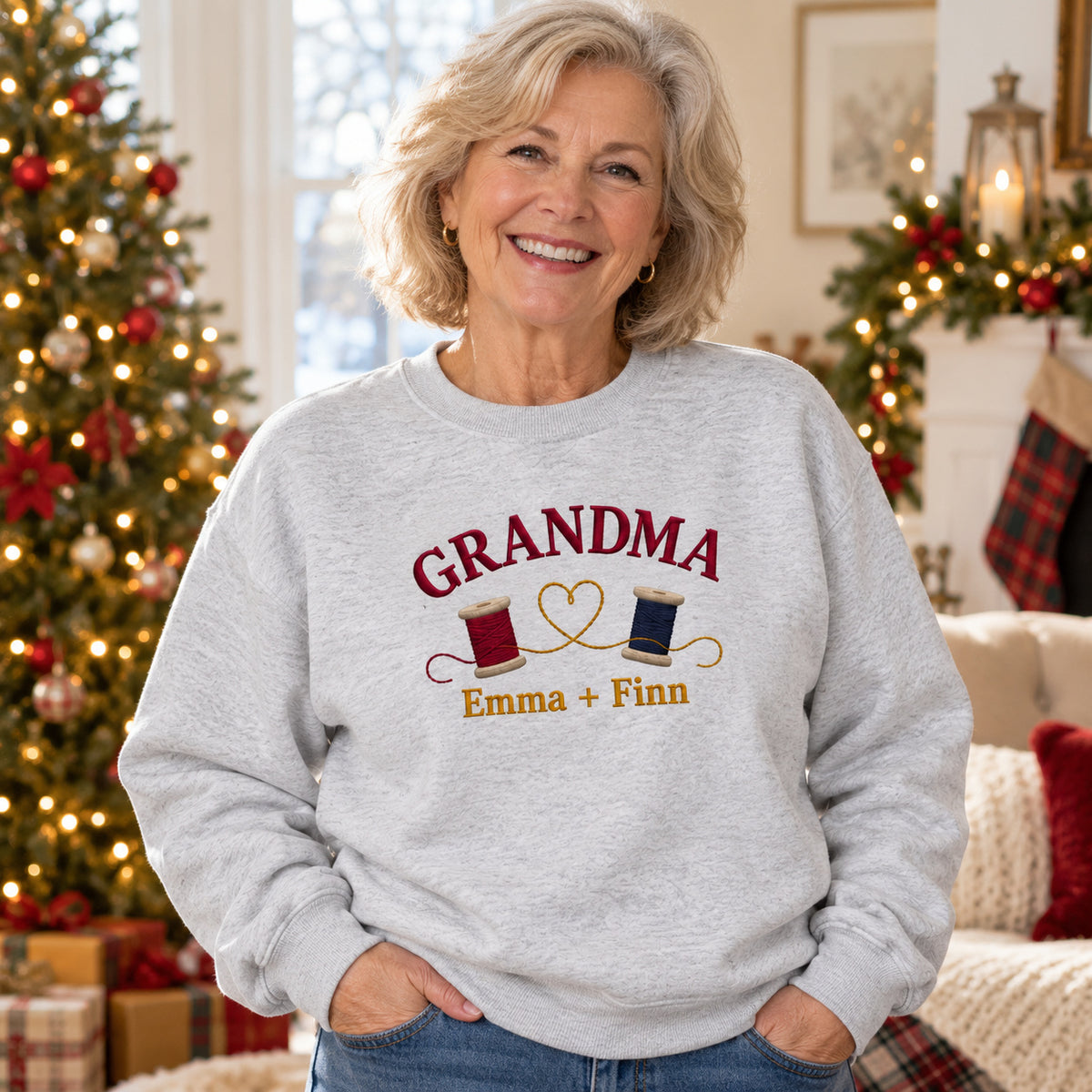 Grandma's Thread Spools sweatshirt concept mockup featuring two thread spools connected by a heart-shaped thread, sample personalization Emma + Finn, lifestyle view