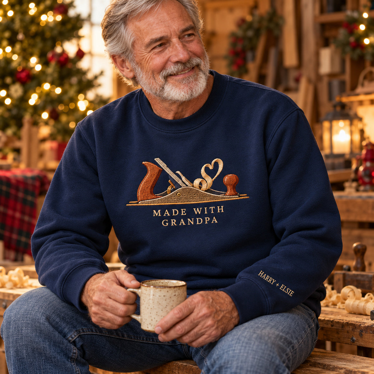 Made with Grandpa Woodwork sweatshirt concept mockup featuring a woodworking hand plane with curling wood shavings, sample personalization HARRY + ELSIE, lifestyle view