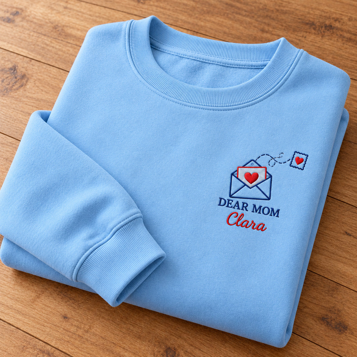 Dear Mom Letter sweatshirt concept mockup featuring an open envelope with a red heart letter and matching heart postage stamp, sample personalization Clara, personalization view