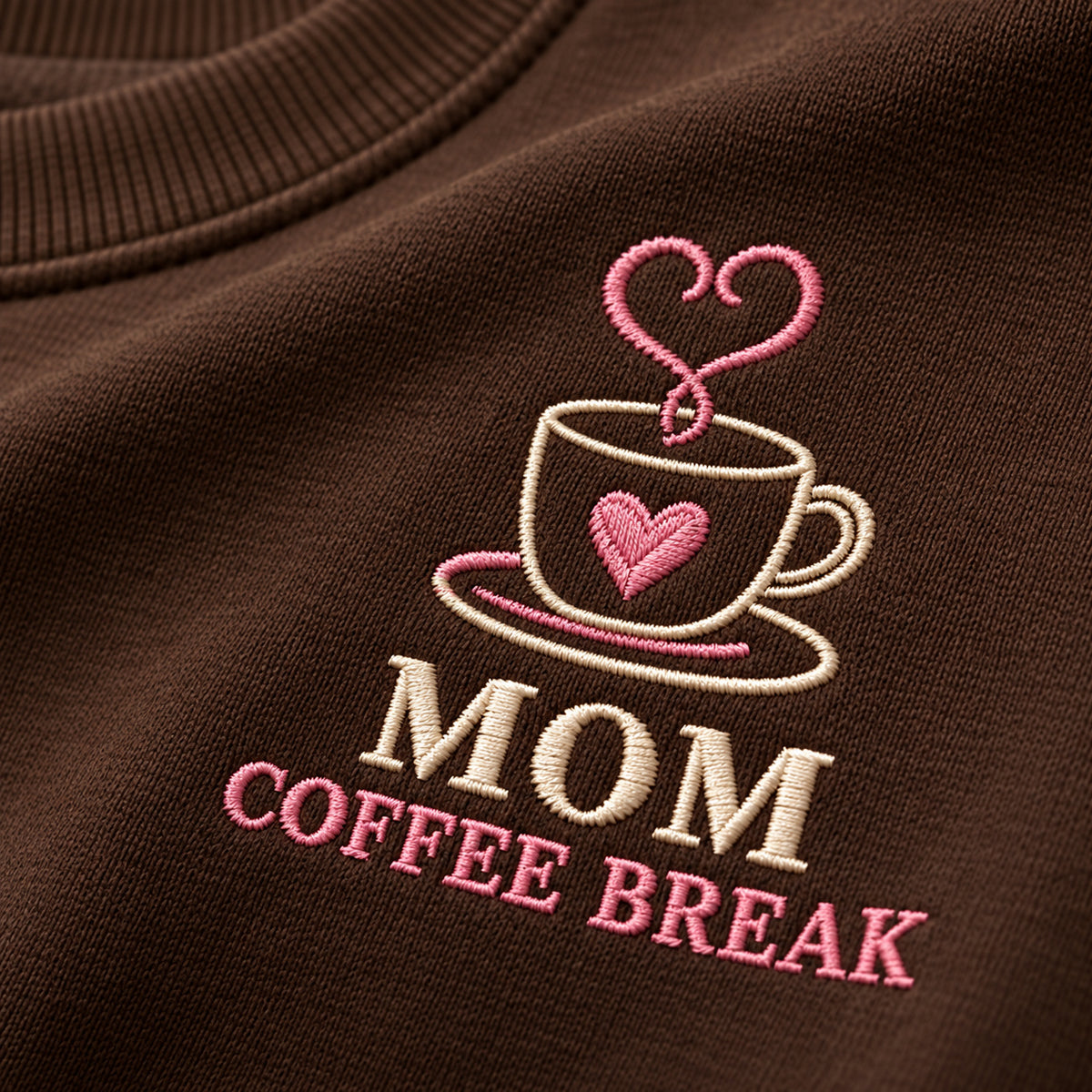 Mom's Coffee Break sweatshirt concept mockup featuring a coffee cup with a heart and heart-shaped steam, sample personalization Nora, embroidery view