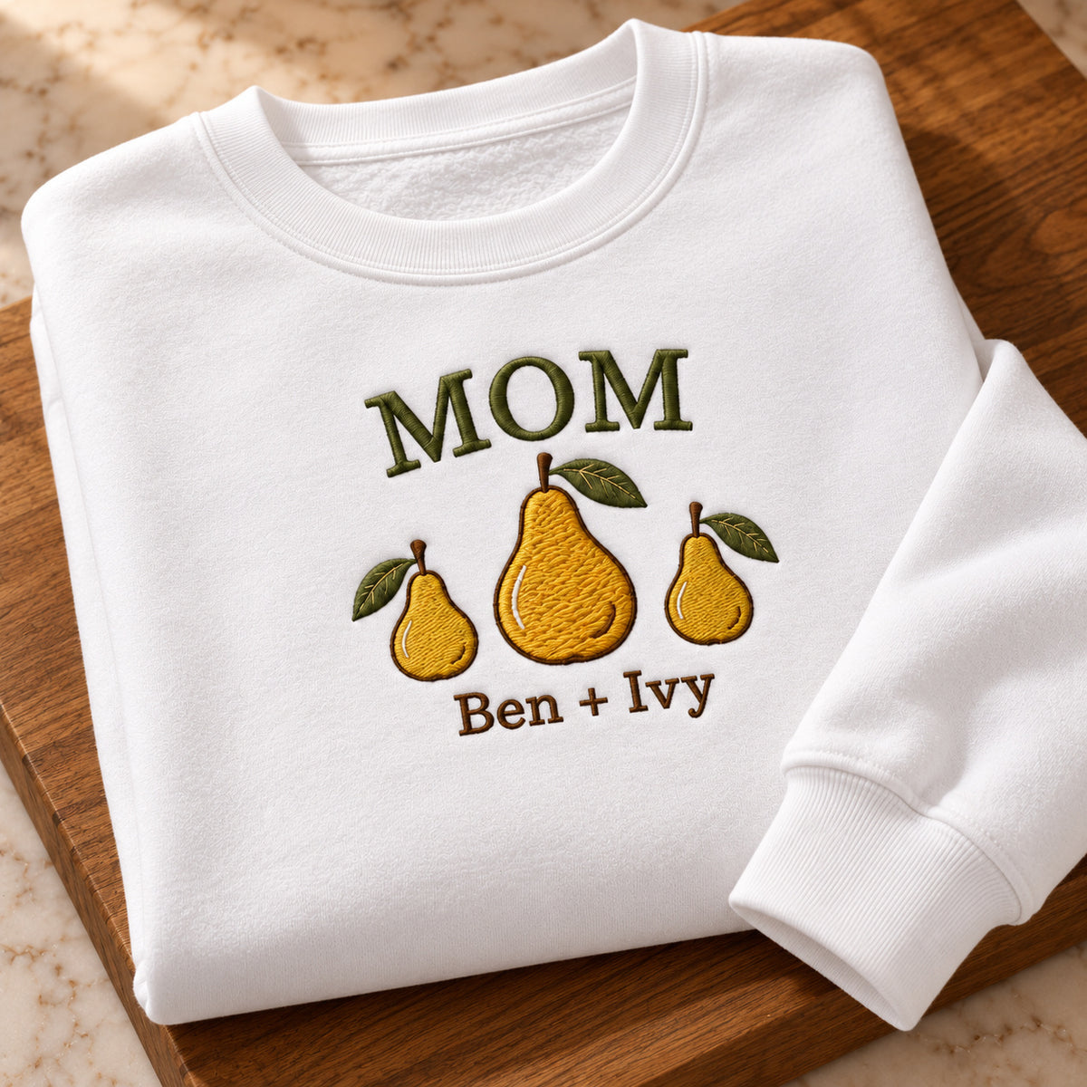 Mom and Two Pears sweatshirt concept mockup featuring a large pear between two smaller pears, sample personalization Ben + Ivy, personalization view